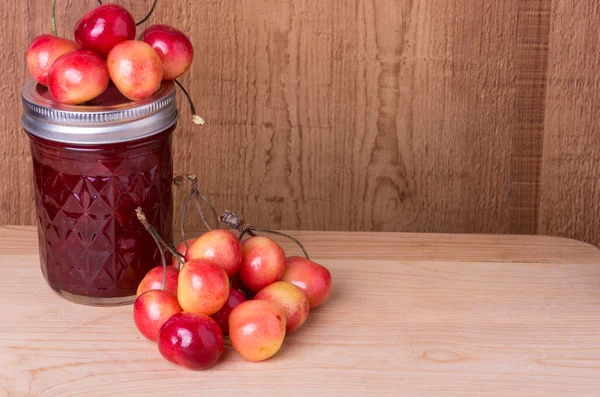 Cherries with jar of jam — Stock Photo, Image