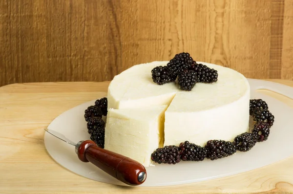 Block of cheese with blackberries — Stock Photo, Image