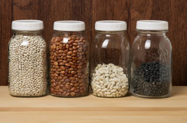 Beans in glass canisters in a kitchen clipart