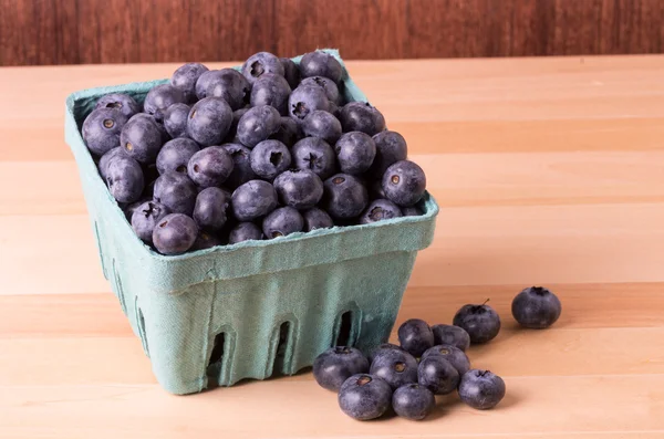 Blueberries in container and on table — Stock Photo, Image