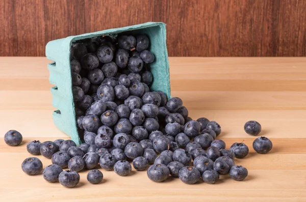 Blueberries spilling from container — Stock Photo, Image