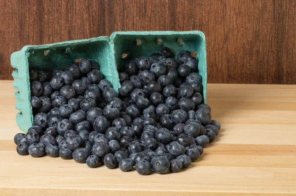 Blueberries spilling from two green containers — Stock Photo, Image