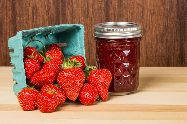 Strawberries in container with jam or jelly — Stock Photo, Image