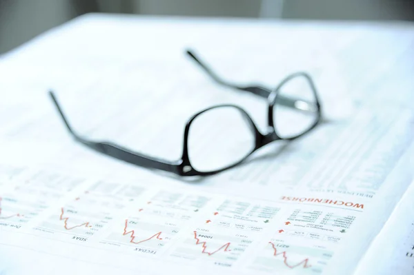 Glasögon på en finansiell tidning — Stockfoto
