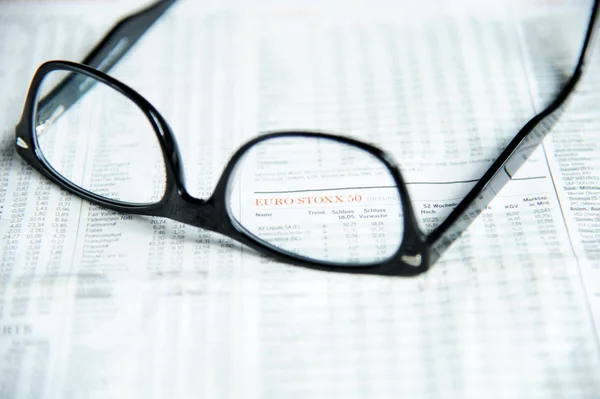 Glasses on a financial newspaper — Stock Photo, Image
