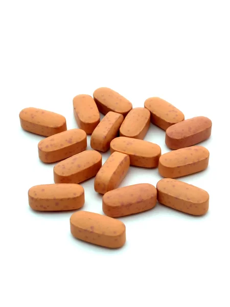 Oranje pillen geïsoleerd op een witte achtergrond verticale — Stockfoto
