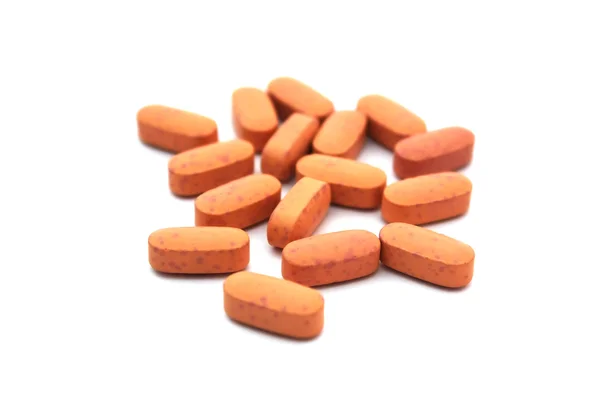 Comprimidos laranja isolado no fundo branco horizontal — Fotografia de Stock
