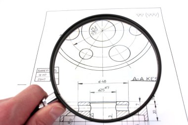 Reviewing technical drawing with magnifying glass. Focus on technical drawing. clipart