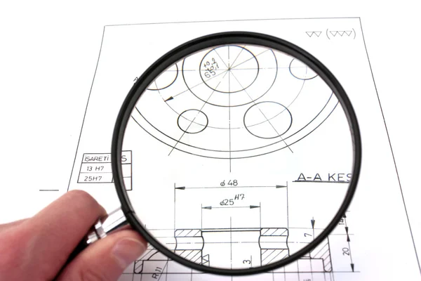 Reviewing technical drawing with magnifying glass. Focus on technical drawing. — Stock Photo, Image