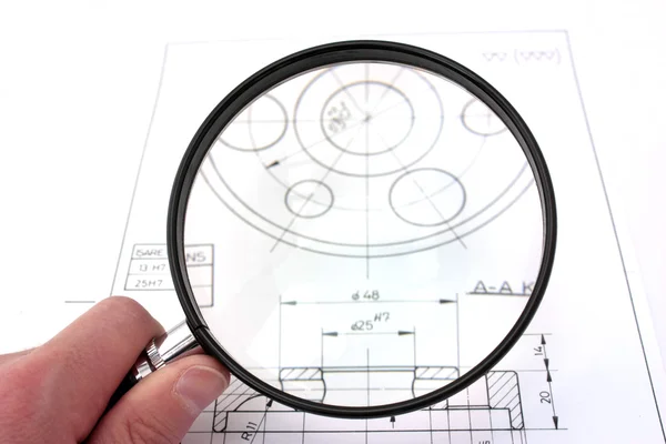Reviewing technical drawing with magnifying glass. Focus on magnifying glass. — Stock Photo, Image