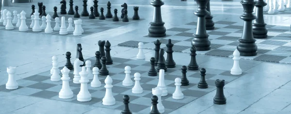 Schackpjäser i olika storlek på en schack styrelser - blå nyans — Stockfoto