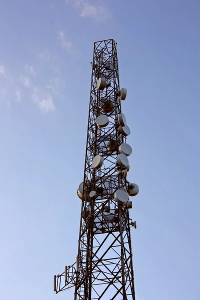 Antenne d'émetteur de téléphone cellulaire isolée dans le ciel. Vertical — Photo