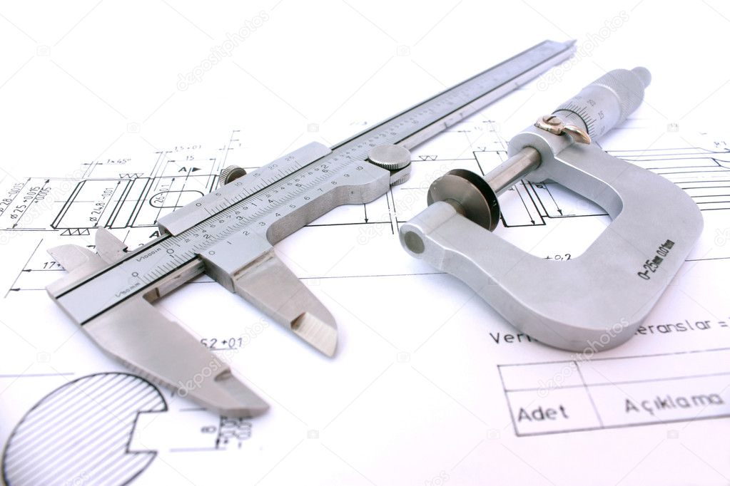 Caliper and Micrometer on blueprint horizontal close up.