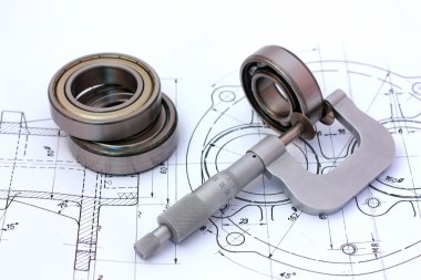 Micrometer measuring ball bearing on technical drawing clipart