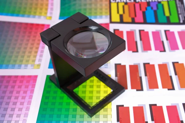 Ampliação de vidro no guia de cores e na amostra. Seleção de cores Pré-Press concept — Fotografia de Stock