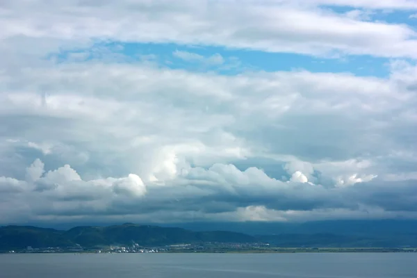 Cloudscape over sea and mountains — Stock Photo, Image