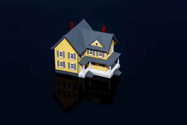 Casa em miniatura isolada sobre fundo preto — Fotografia de Stock