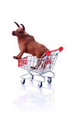 Model cow in shopping cart isolated on white clipart