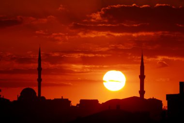 Red sunset scene with mosque and minarets clipart