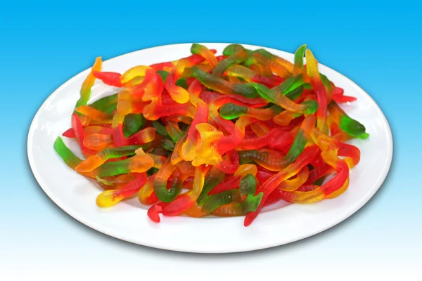 Egy tányér színes féreg alakú zselés cukorka — Stock Fotó