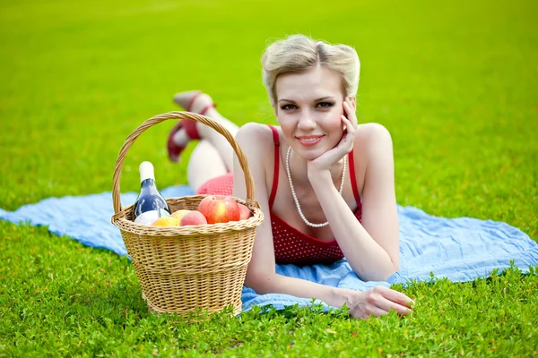 Mladá blonďatá žena leží na trávě — Stock fotografie