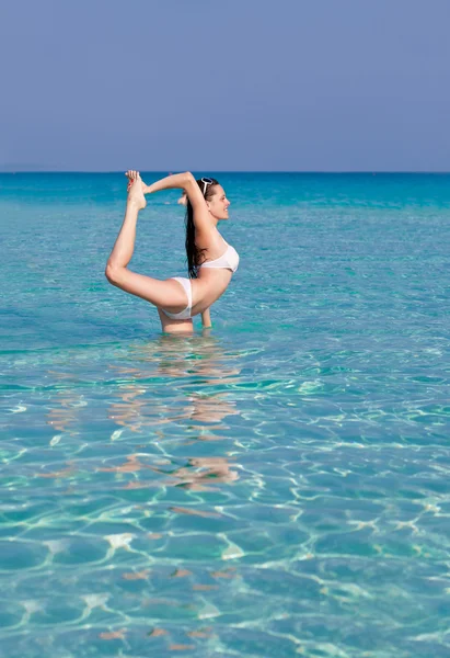 一个女人锻炼灵活性在海 — 图库照片