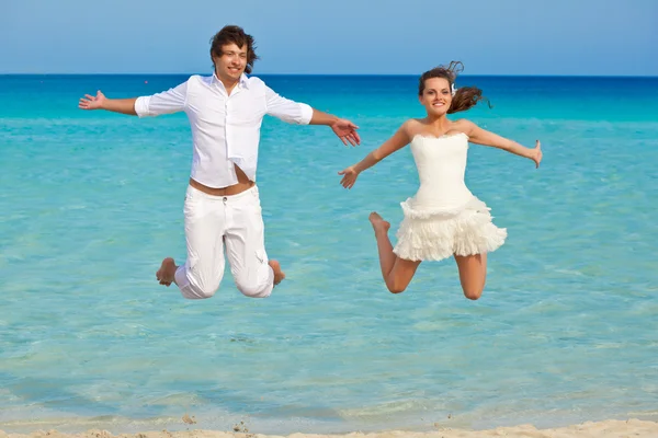 Het echtpaar is springen in de zee — Stockfoto