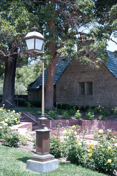 Kamenný dům s krásnou slunnou zahradou — Stock fotografie