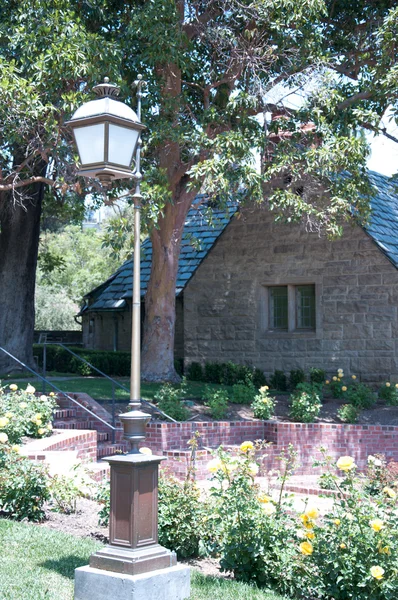 Каменный дом с красивым солнечным садом — стоковое фото