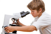 fiatal diák, keres mikroszkóppal.