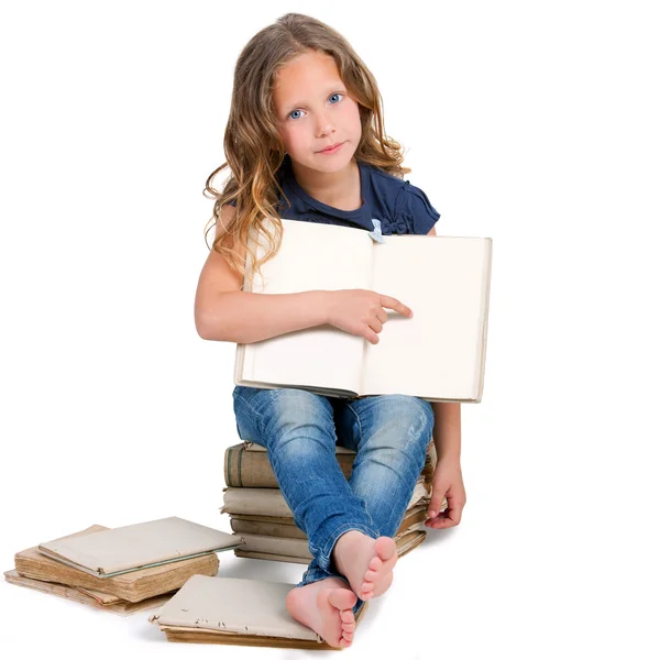 Meisje, zittend op stapel van oude boeken. — Stockfoto