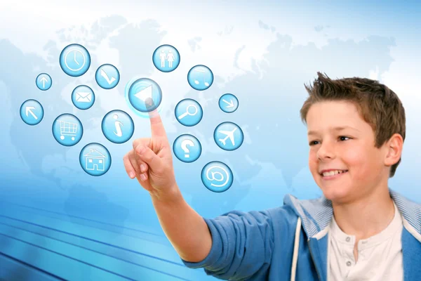 Boy pointing at web icons with futuristic interface. — Stock Photo, Image