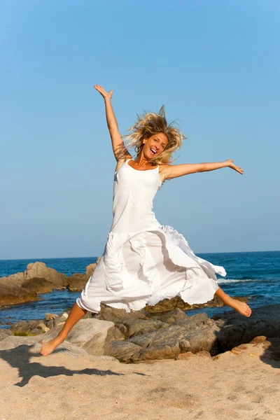 Attractive woman in white jumping outdoors. — Stock Photo, Image