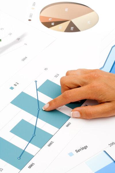 Женская рука, указывающая на финансовую графику
.