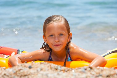 Girl having fun on air mattress. clipart