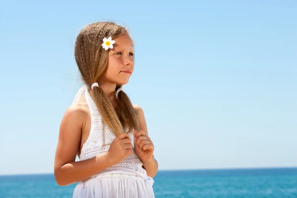 Söt flicka på stranden stirrar. — Stockfoto