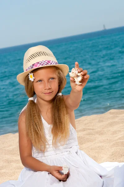 셸 보이는 바닷가에 달콤한 소녀. — 스톡 사진