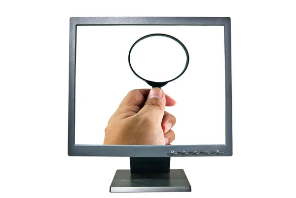 Lidská ruka držící lupu na monitoru — Stock fotografie