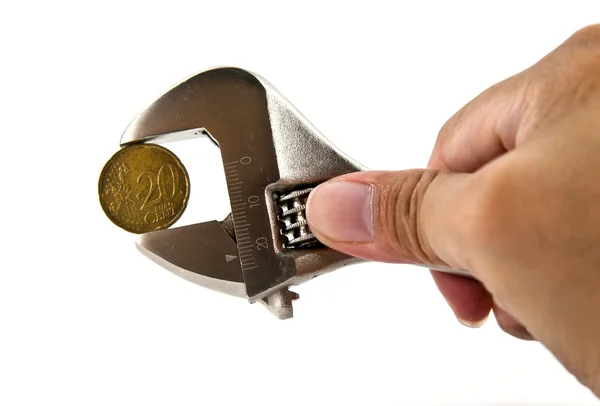 Hånden som holder en skiftenøkkel med euromynten – stockfoto