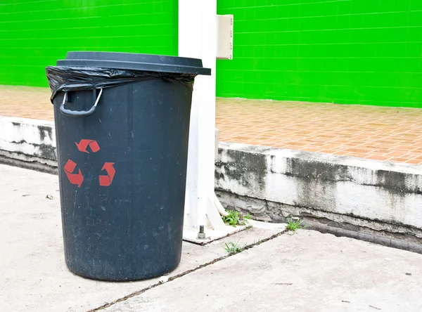 Schwarzer Mülleimer mit rotem Recyclingschild — Stockfoto