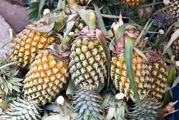 Куча ананасов в рыночной ларьке — стоковое фото