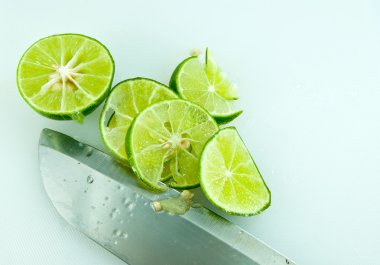 Sliced lime and knife on kitchen board