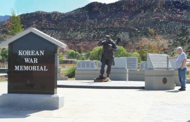 Old soldier remembering fallen friends at Korean War Memorial clipart