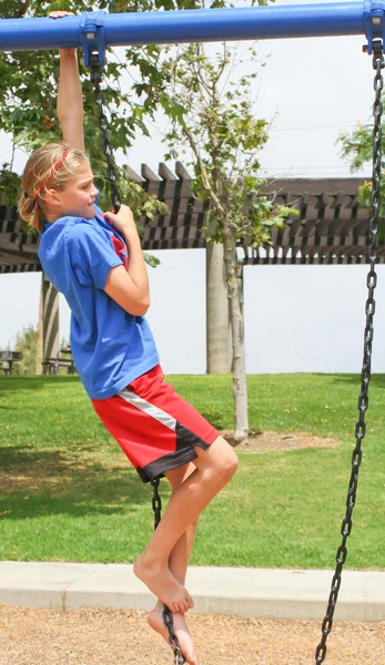 Teenage girl climbing swing chain — Stock Photo, Image