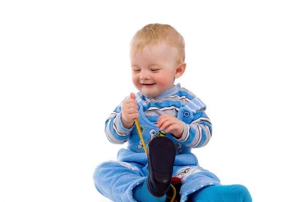 Uma criança pequena tentando vestir sapatos — Fotografia de Stock