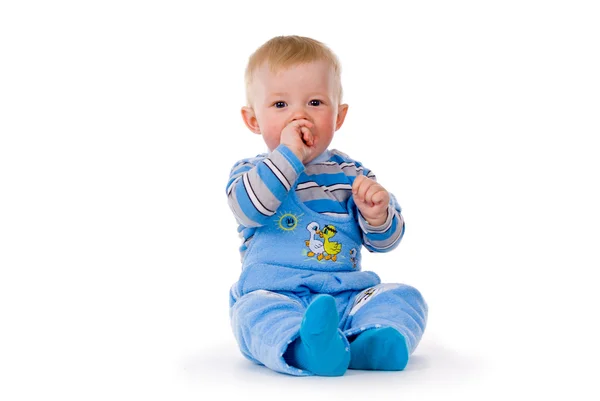 Dziecko siedzi, ręka w ustach — Zdjęcie stockowe
