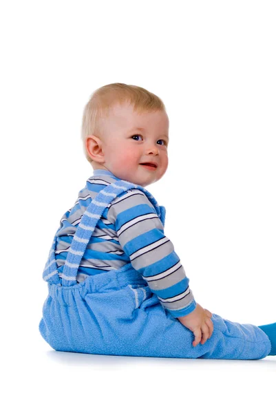 Een klein kind zit en lacht — Stockfoto