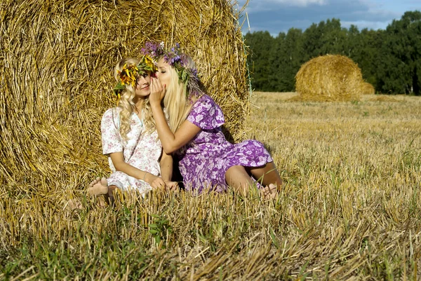 美しい少女、干し草の山のそばに座って — ストック写真