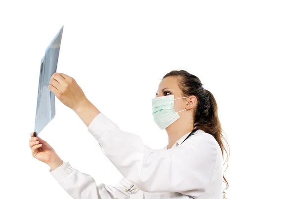 Lékař v masce zvažuje rentgenové fotografie — Stock fotografie