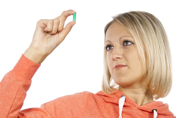 Girl looks at the pill — Stock Photo, Image